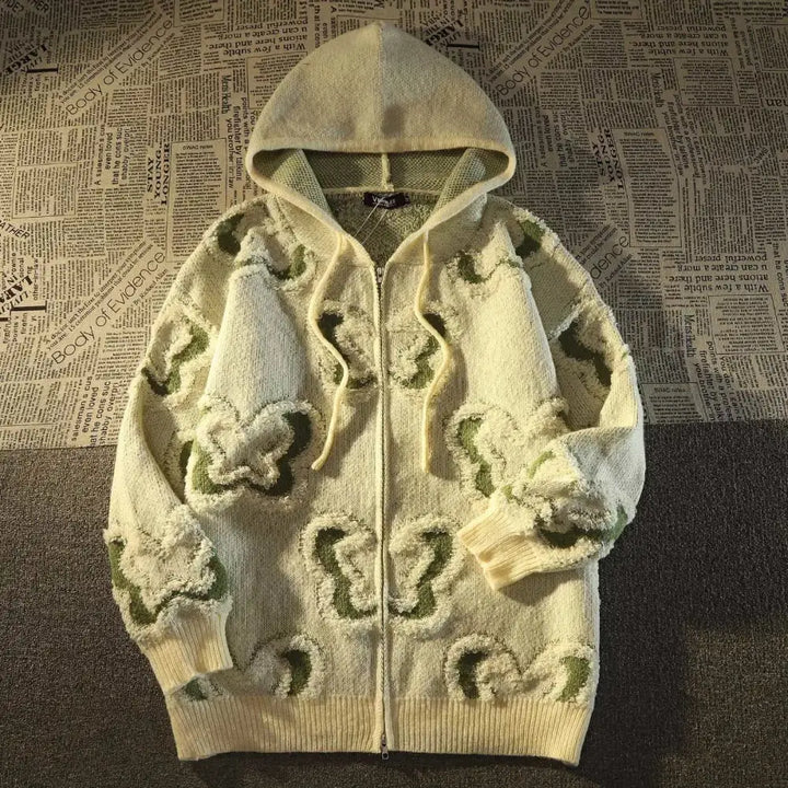 un pull blanc avec un sweat à capuche et une fleur verte sur la capuche