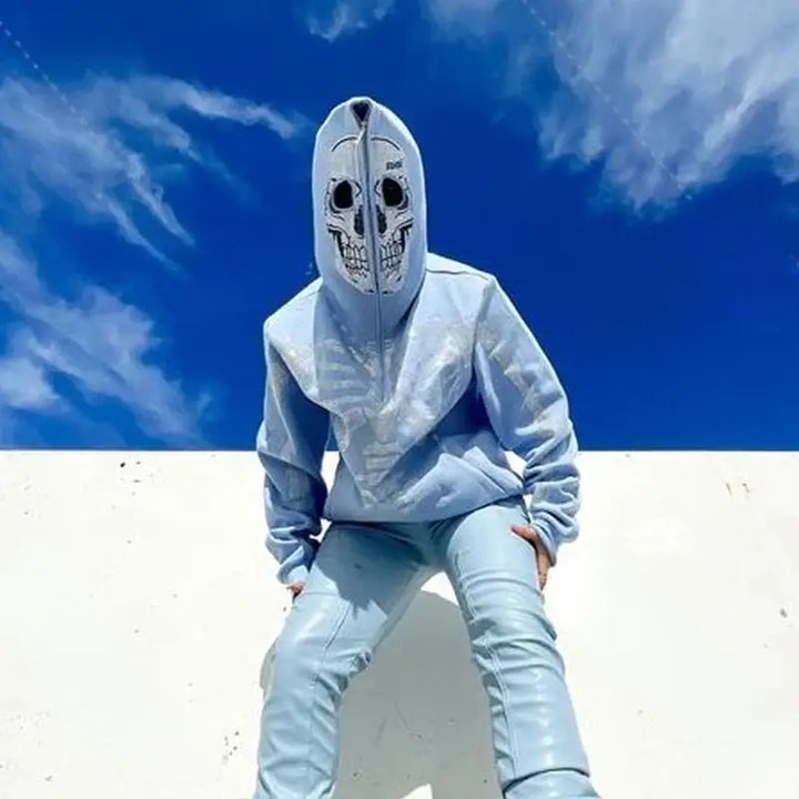 a man wearing a blue hoodie and white sneakers
