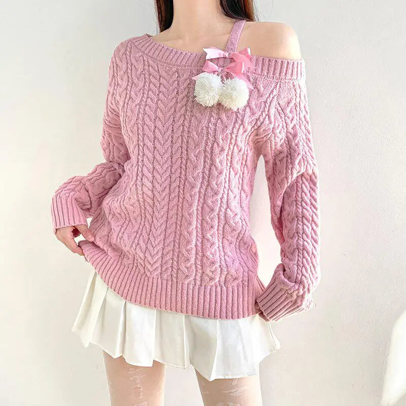 Soft pink knit sweater with cut-out shoulders and pompom details