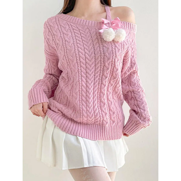 Soft pink knit sweater with cut-out shoulders and pompom details