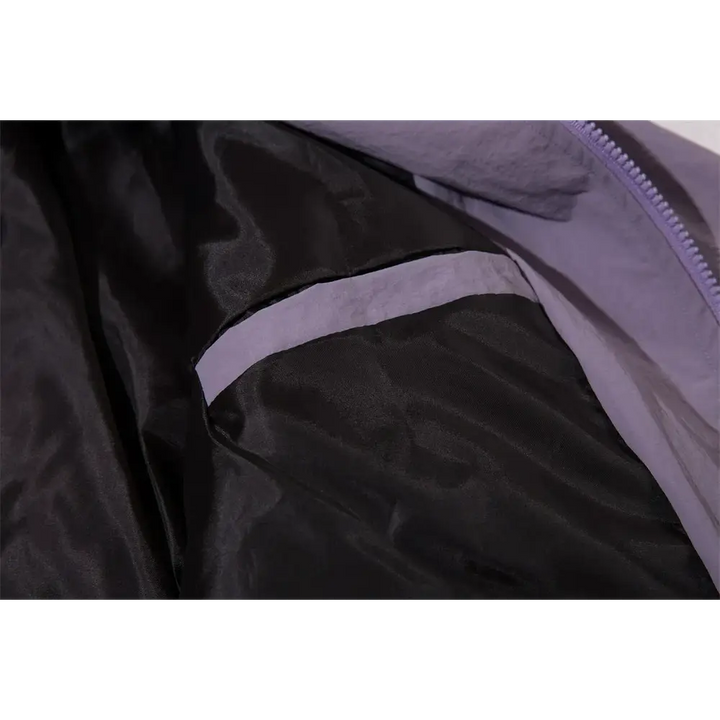une veste noire avec une fermeture éclair violette